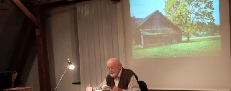 Josef Fendl liest. Im Hintergrund ein Bild vom Schindler-Stadel